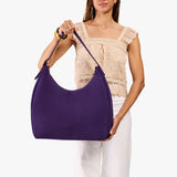 Imperial Oversized | Model holding u-shaped, flat-bottomed leather shoulder bag with adjustable strap