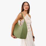 Laurel Oversized | Model holding u-shaped, flat-bottomed leather shoulder bag with adjustable strap