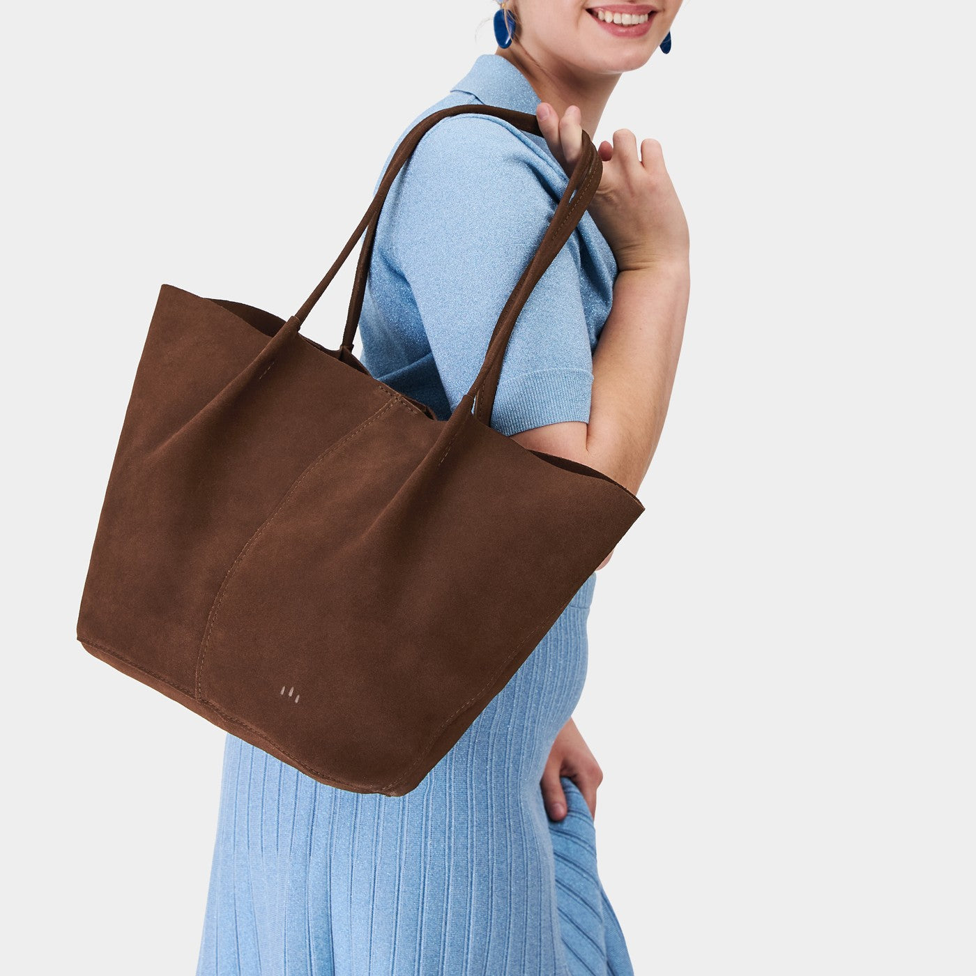 Stagecoach*Oversized | Model holding extra wide bucket shaped tote bag with matching leather handles