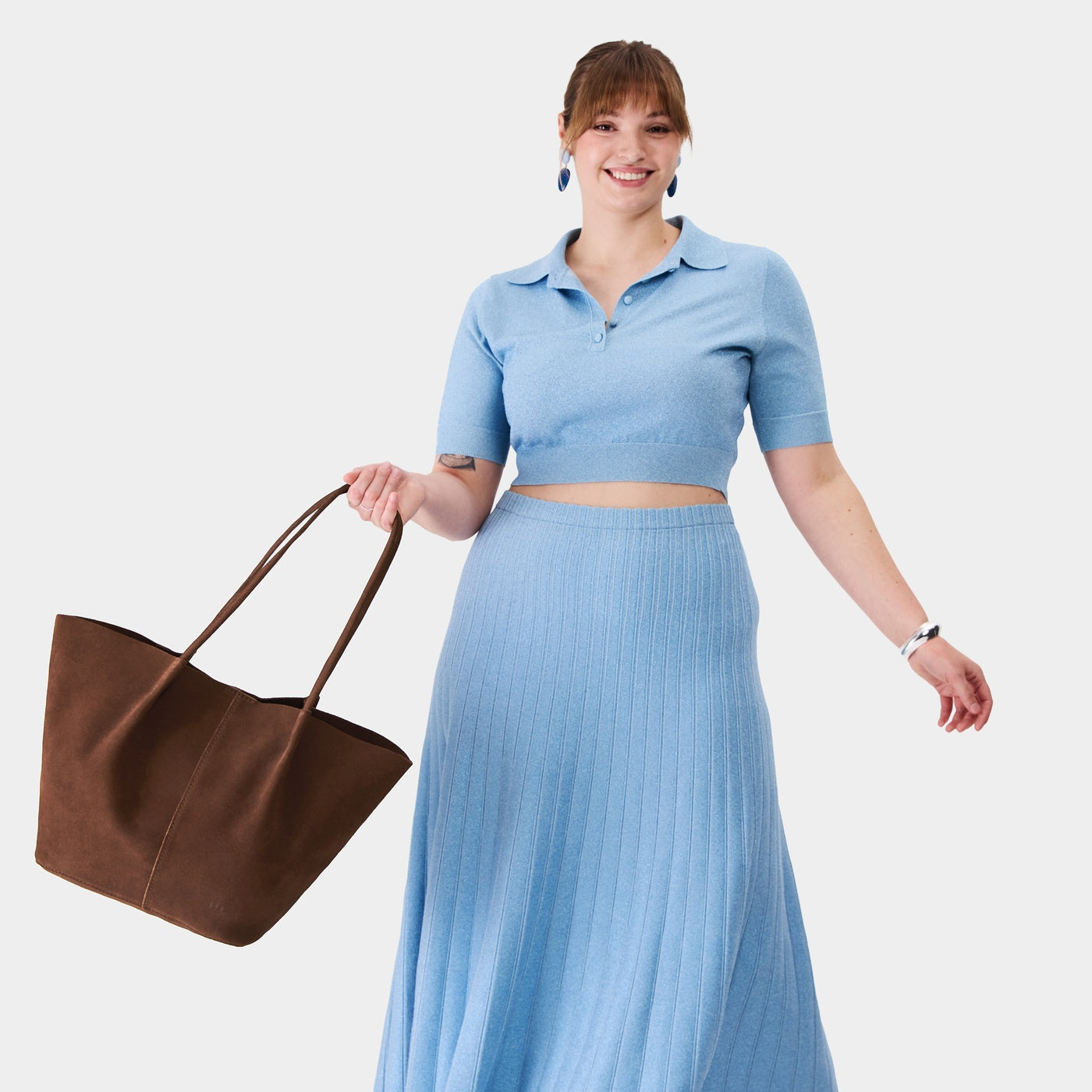 Stagecoach*Oversized | Model holding a  leather tote bag 