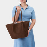 Stagecoach Oversized | Model holding extra wide bucket shaped tote bag with matching leather handles