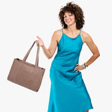Sparrow Oversized East/West | Model holding structured wide tote bag with overlapping panels and crossbody strap