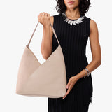 Toasted Oat Oversized | Model holding large shoulder bag with adjustable strap and magnetic snap closure
