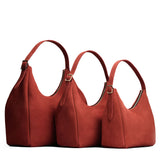 Cinnabar | Size comparison image of oversized, large, and medium u-shaped, flat-bottomed leather shoulder bags with adjustable strap