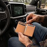 Naturale | A person sitting inside a vehicle holding an open card holder