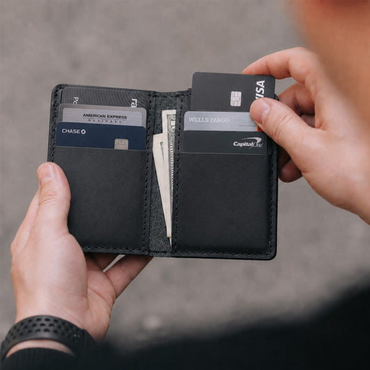 Nero | An open card holder with hands pulling cards out of one of the interior card slots