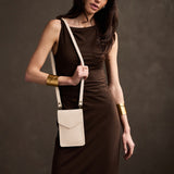 Pebbled Bone | Model wearing slim, phone-shaped crossbody purse with magnetic closure