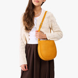 Sunshine | A model wearing a rounded children's adjustable crossbody bag