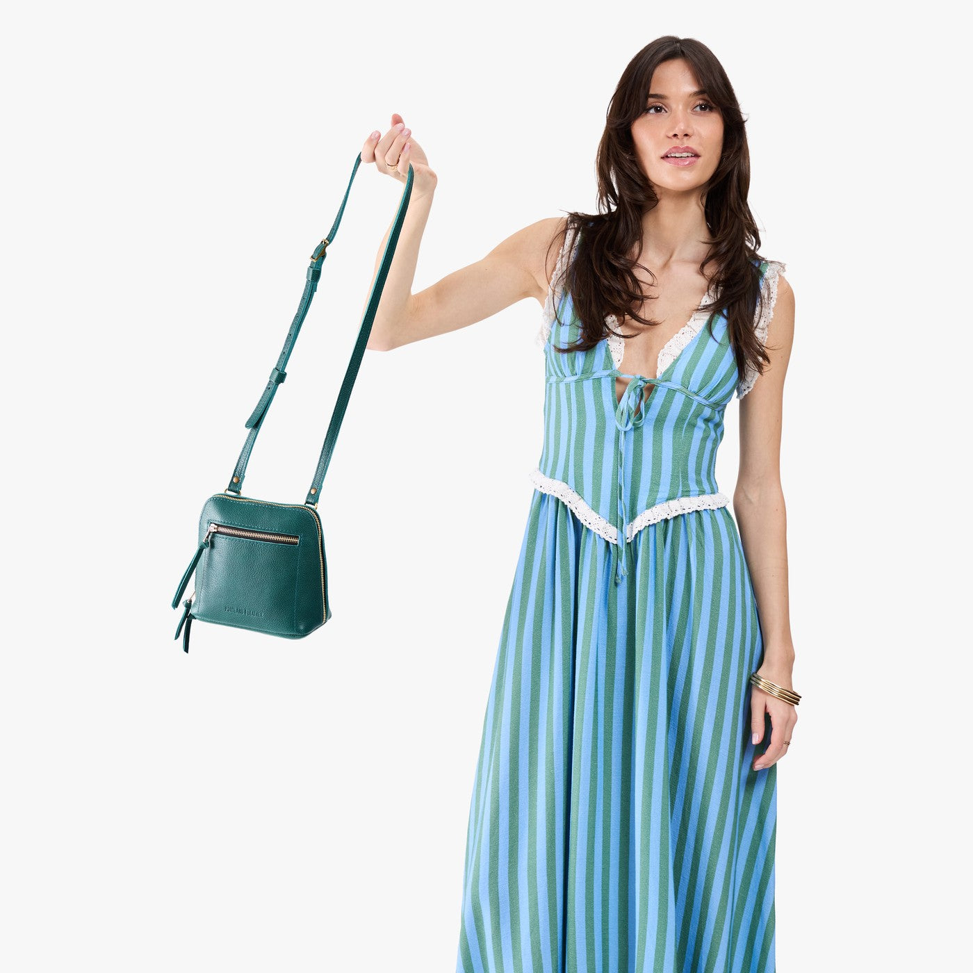 Sea Glass*Small | Model carrying compact leather bag with top zipper, front zipper pocket, and adjustable crossbody strap