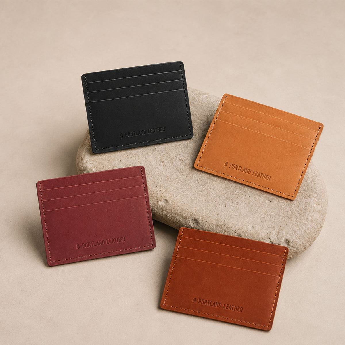 Toscano | Group of wallets displayed on a light colored stone
