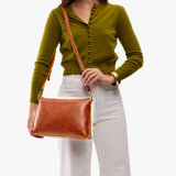 Sienna Large | Model holding a zip top crossbody bag with detachable strap