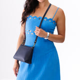 Night Owl Small | A Model holding a zip top crossbody bag with detachable strap
