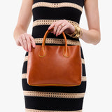 Sienna Large | Model wearing a mid-size tote purse with  structured leather handles and crossbody strap