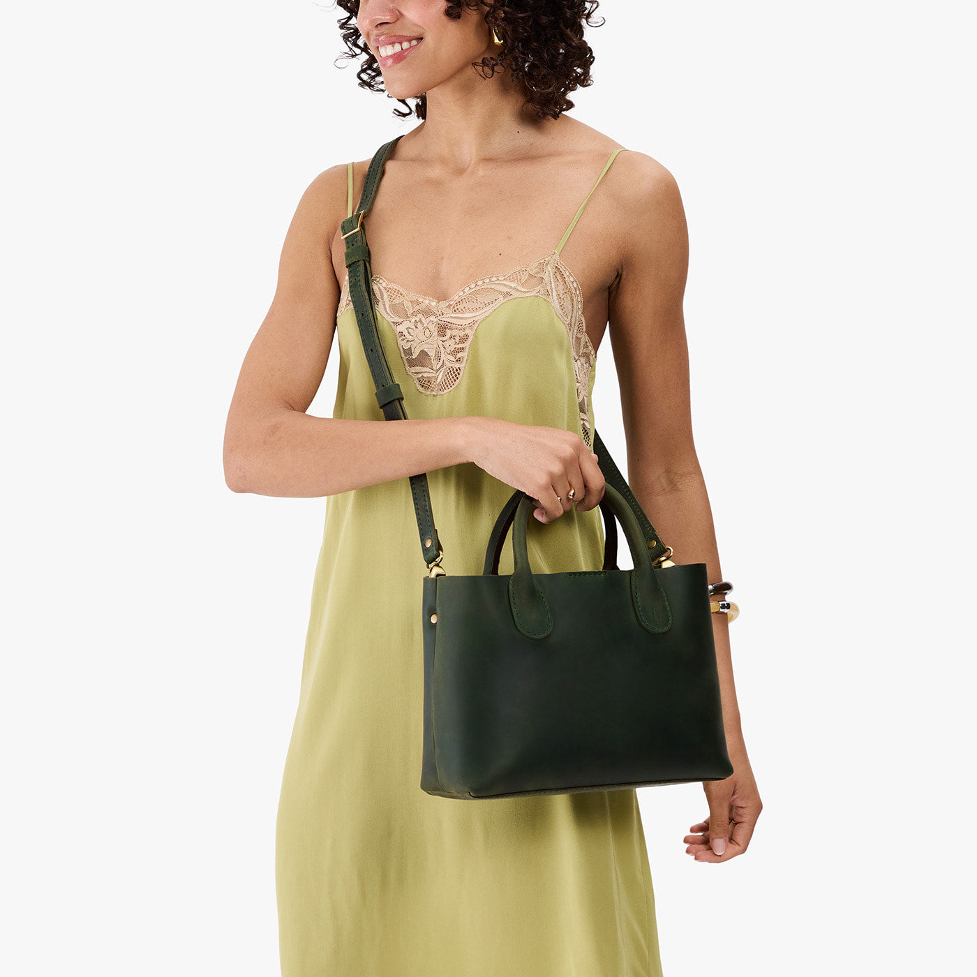 Evergreen*Large | Model wearing a mid-size tote purse with  structured leather handles and crossbody strap