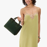 Evergreen Large | Model wearing a mid-size tote purse with  structured leather handles and crossbody strap