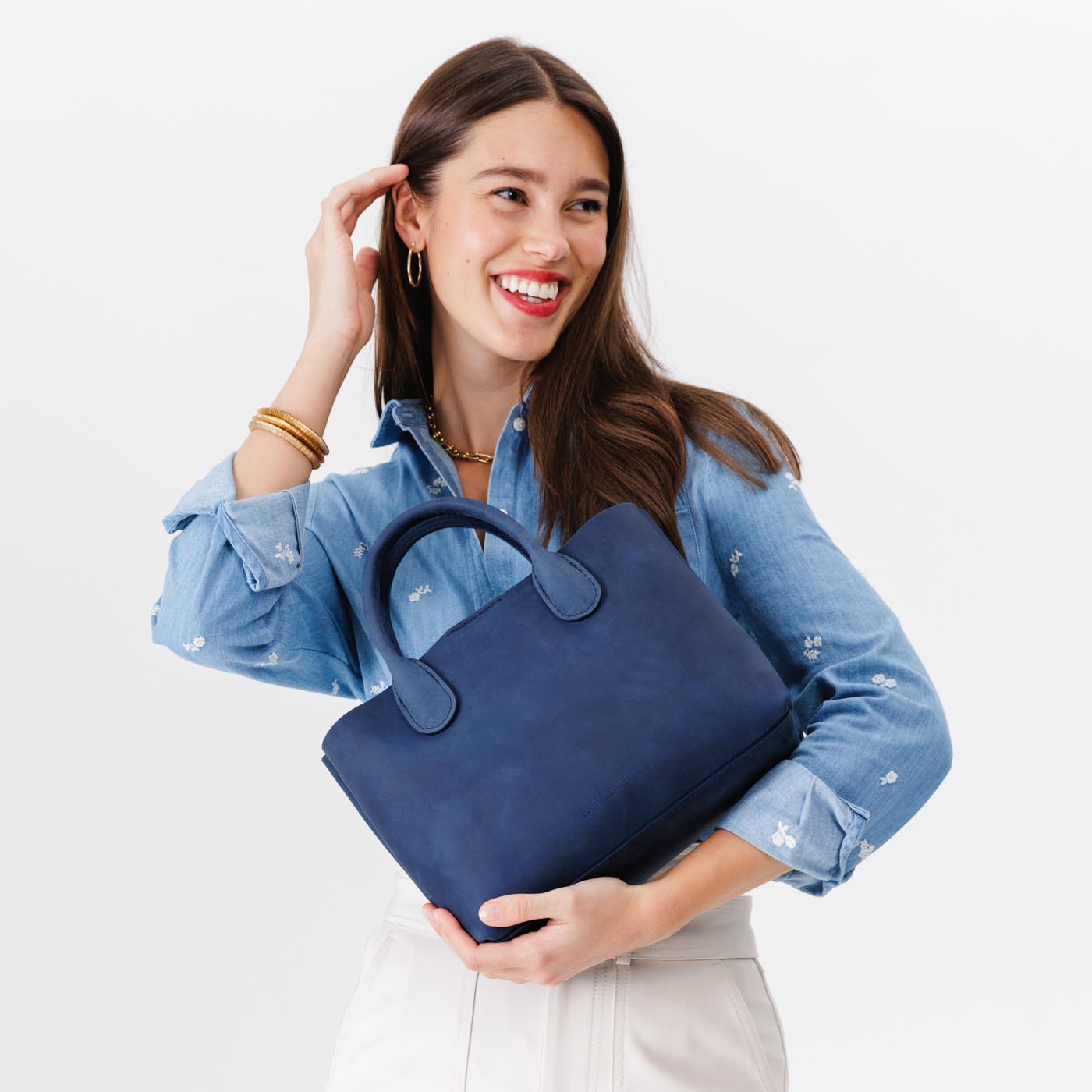 Deep Water*Large | Model holding mid-size tote purse with  structured leather handles and crossbody strap