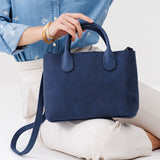 Deep Water Large | Model holding mid-size tote purse with  structured leather handles and crossbody strap