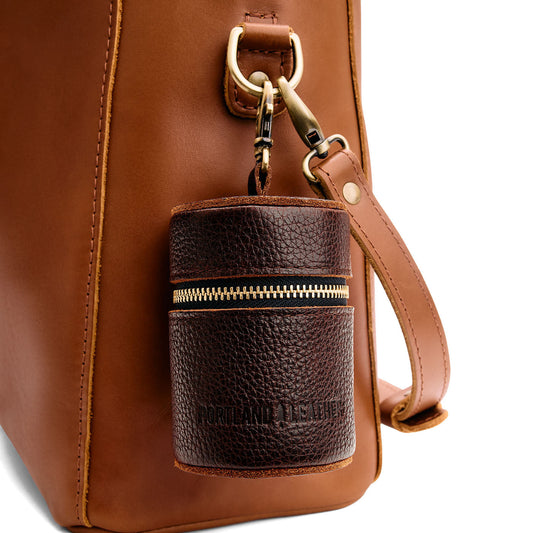 Coldbrew | Cylindrical shaped pouch with a gold zipper and swivel lobster claw clasp on a bag