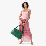 Bacalar Large | A model holding a slouchy triangle shaped shoulder bag with a flap