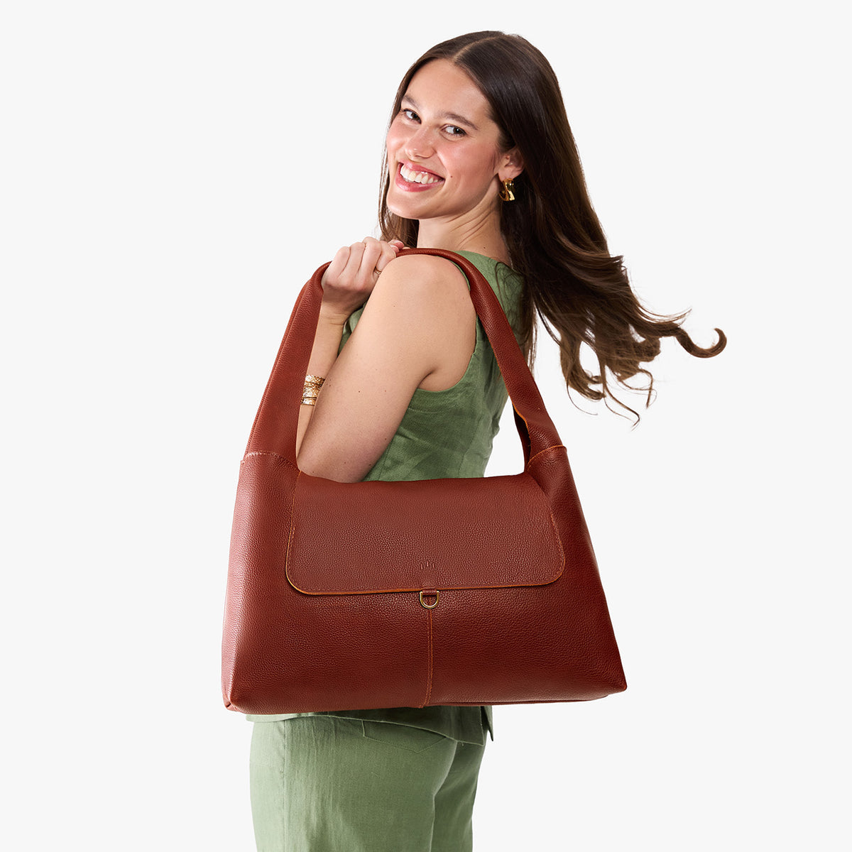 Nutmeg*Large | A model holding a slouchy triangle shaped shoulder bag with a flap