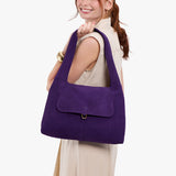 Imperial Medium | A model holding a slouchy triangle shaped shoulder bag with a flap