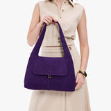 Imperial Medium | A model holding a slouchy triangle shaped shoulder bag with a flap