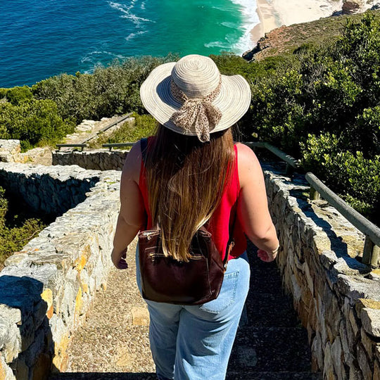 A person walking down stone stairs wearing a Classic Grizzly Tote backpack
