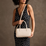 Pebbled Bone Large | Model holding mini duffle shaped handbag with crossbody strap