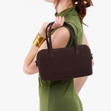 Velvet Brown Large | Model holding mini duffle shaped handbag with crossbody strap