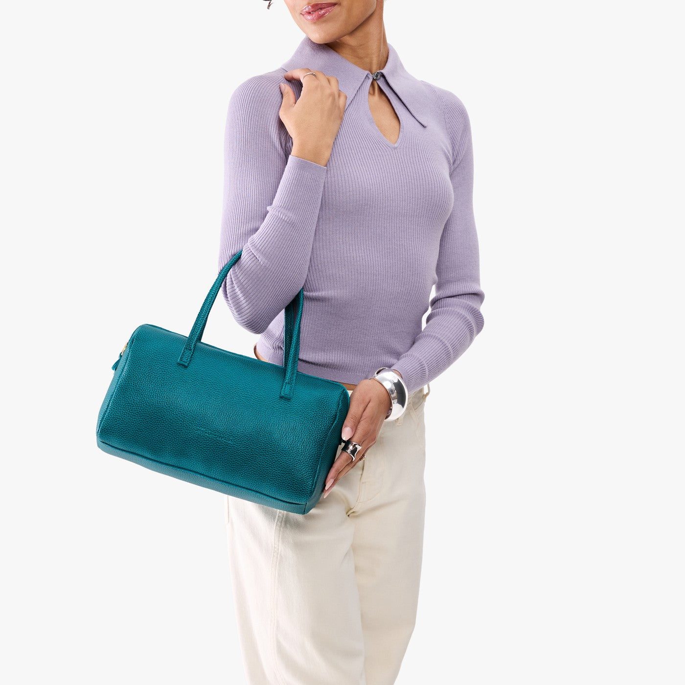 Aquarius*Oversized | Model holding mini duffle shaped handbag with crossbody strap