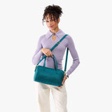 Aquarius Oversized | Model holding mini duffle shaped handbag with crossbody strap