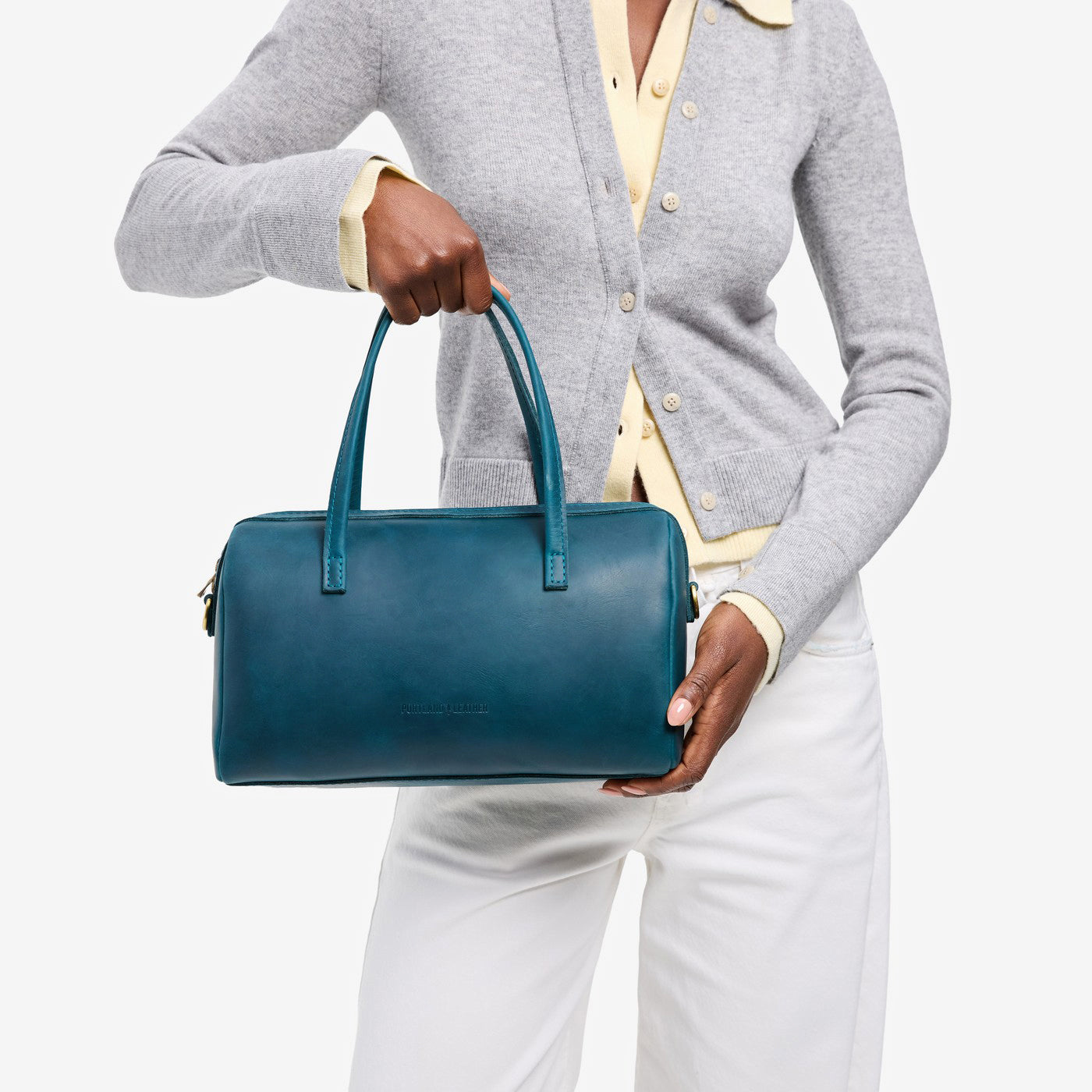 Westward Blue*Oversized | Model holding mini duffle shaped handbag with crossbody strap
