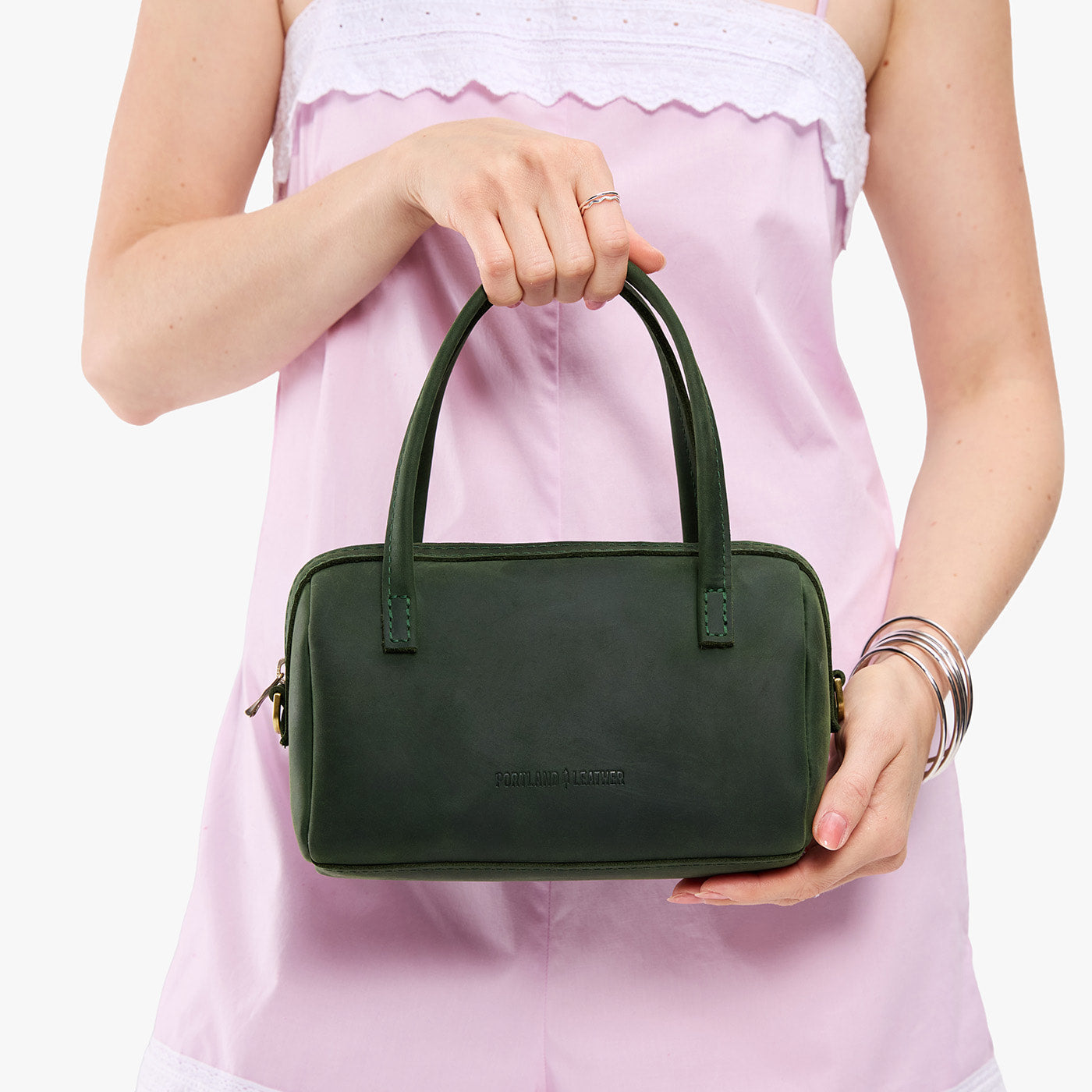 Evergreen*Small | Model holding mini duffle shaped handbag with crossbody strap