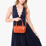 Koi Small | Model holding mini duffle shaped handbag with crossbody strap