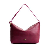 Orchid Large | Model Wearing medium sized slouchy leather shoulder bag with zipper opening and three metal tree emblems