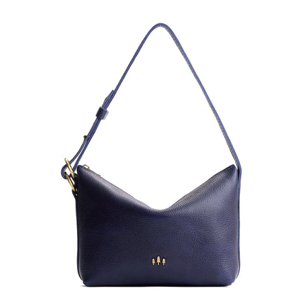 Cobalt*Large | Model Wearing medium sized slouchy leather shoulder bag with zipper opening and three metal tree emblems