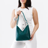 Sea Glass Small | Model wearing petite shoulder bag with adjustable strap and magnetic snap closure