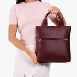 Cabernet Small | Model wearing a convertible tote clutch crossbody