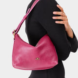 Cosmo Small | Model wearing petite slouchy leather shoulder bag with zipper opening and three metal tree emblems
