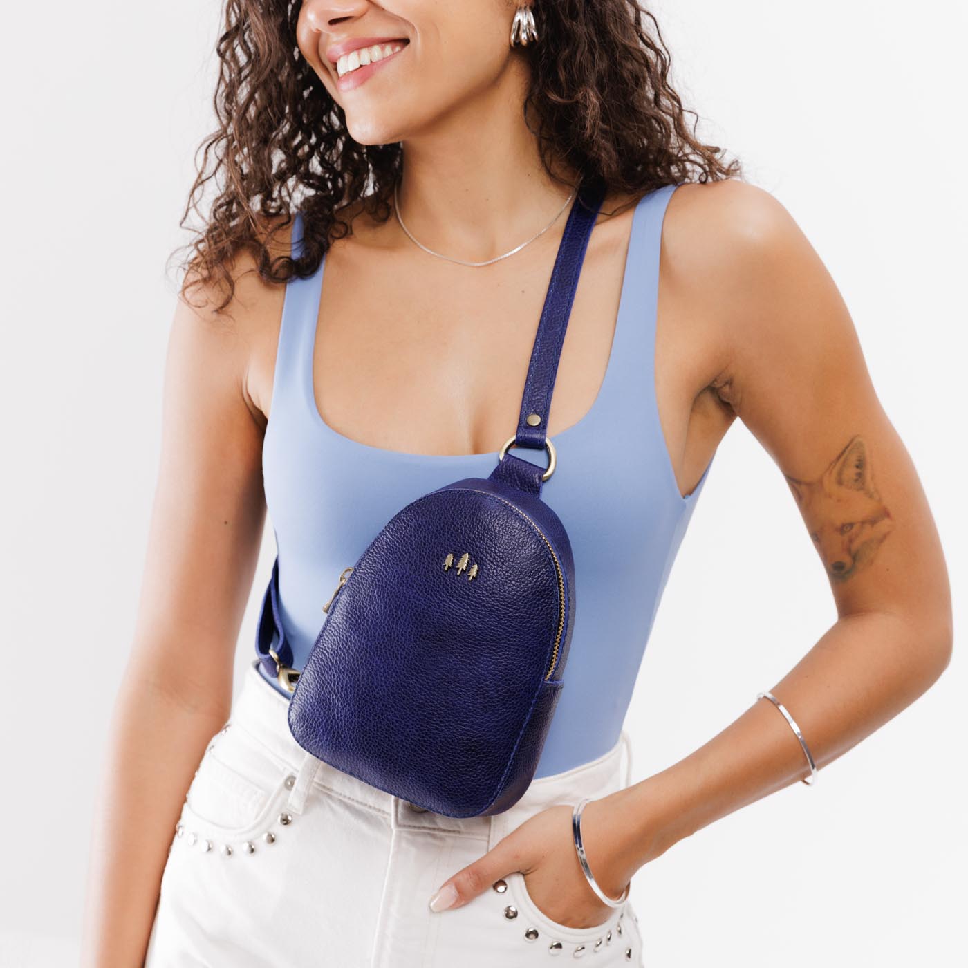 Cobalt | Model wearing small sling bag with zipper closure and adjustable strap