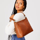 Honey Classic | Model carrying triangular shoulder bag with antiqued brass finished hardware