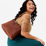 Nutmeg Classic | Model carrying triangular shoulder bag with antiqued brass finished hardware