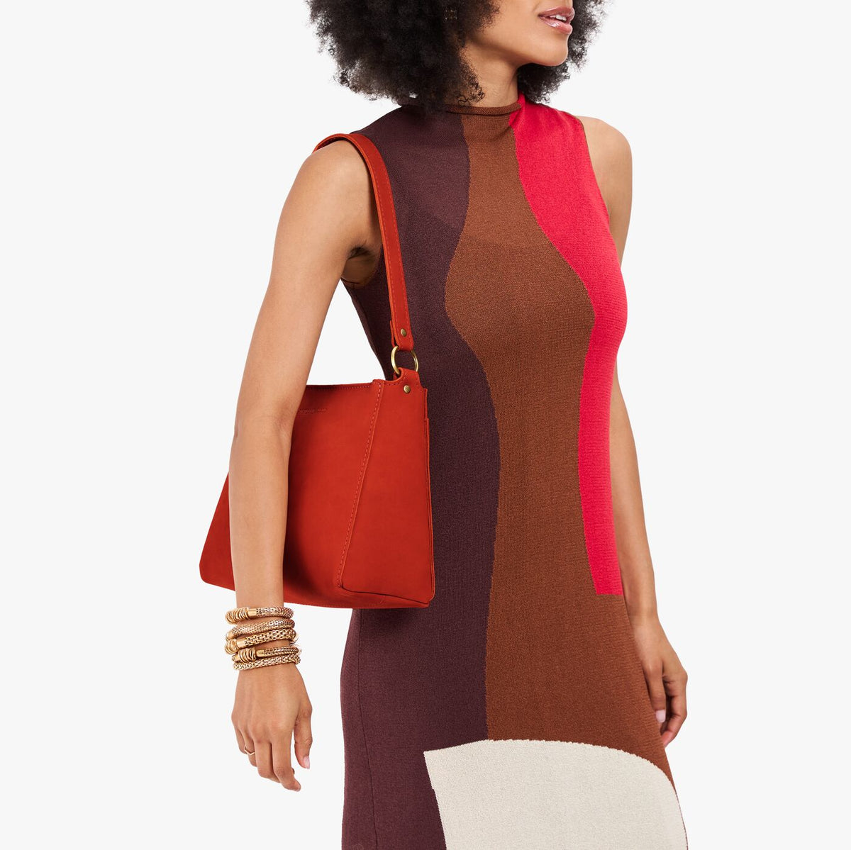 Paprika*Small | Model holding a triangular shoulder bag with antiqued brass finished 