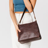 Coldbrew Classic | Model holding triangular shoulder bag with antiqued brass finished hardware