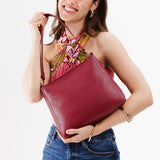 Berry Good Classic | Model holding triangular shoulder bag with antiqued brass finished hardware