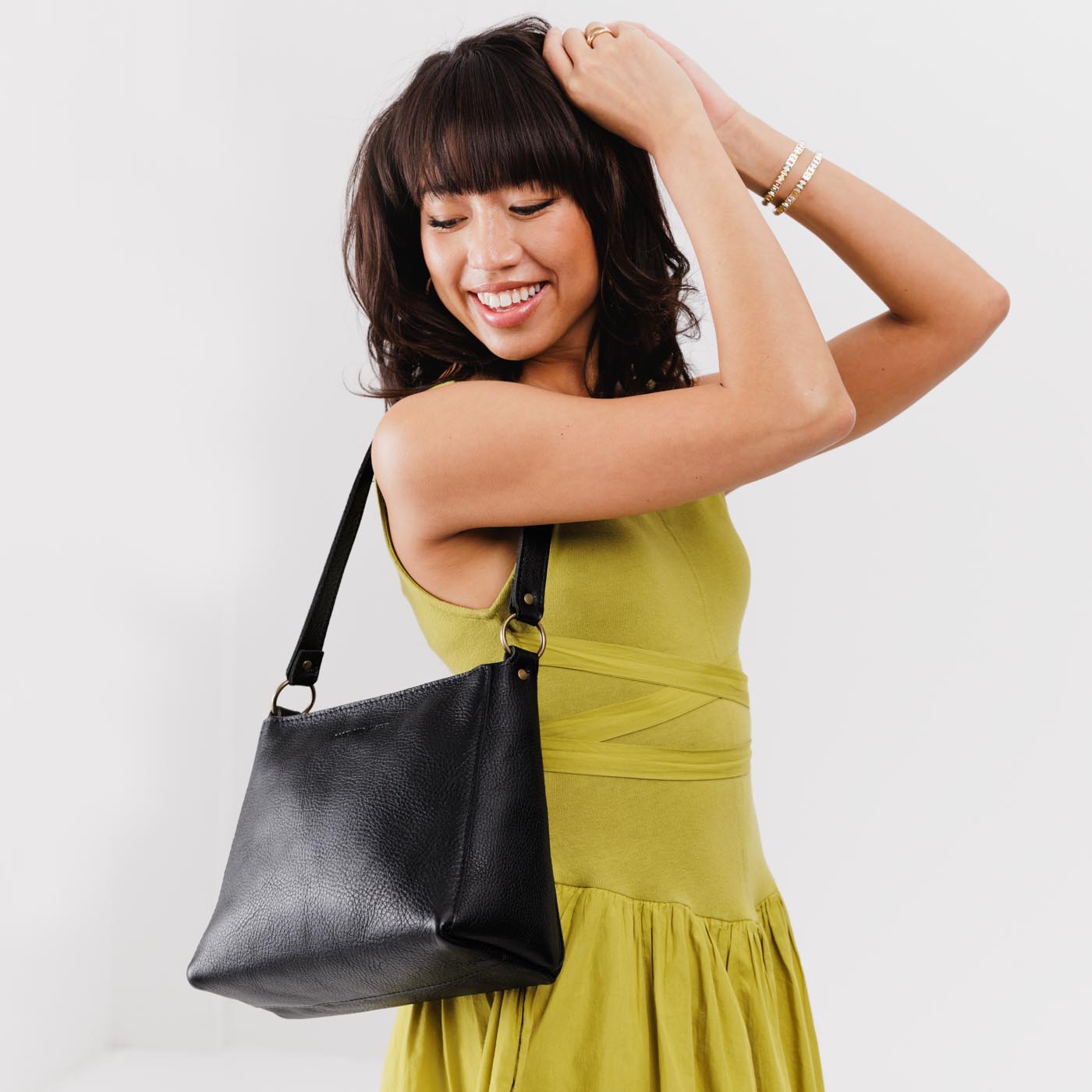 Pebbled--black*Classic | Model carrying triangular shoulder bag with antiqued brass finished hardware