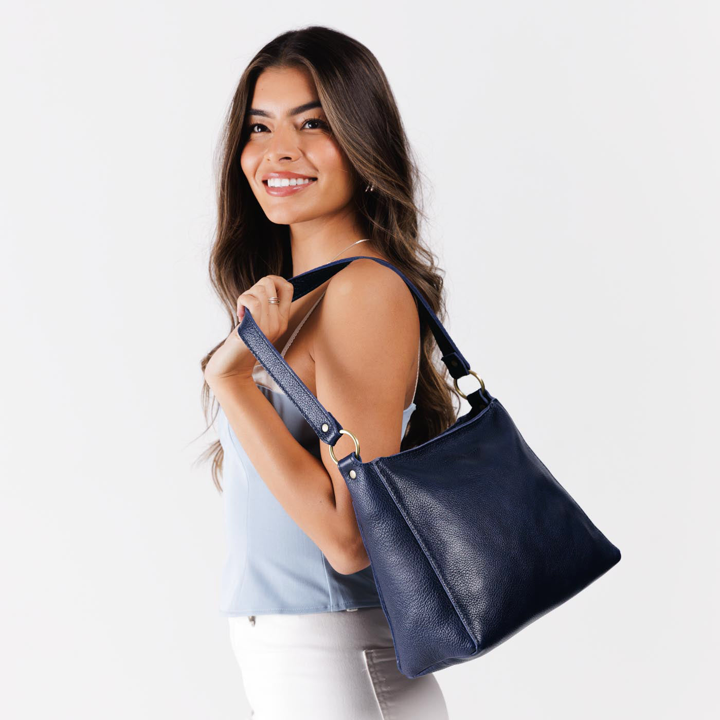 Cobalt*Classic | Model carrying triangular shoulder bag with antiqued brass finished hardware