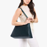 Boreal Large | Model carrying large triangular shoulder bag with antiqued brass finished hardware