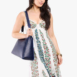 Cobalt Large | Model carrying large triangular shoulder bag with antiqued brass finished hardware