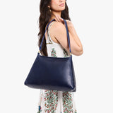 Cobalt Large | Model carrying large triangular shoulder bag with antiqued brass finished hardware
